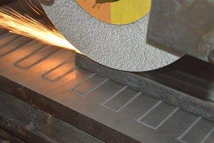 Surface grinder finishing a steel tool